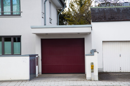 modern garage with wine red garage door, new constructionの写真素材