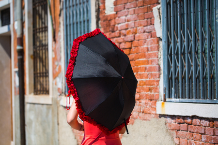 Woman from behind with umbrella in Veniceの写真素材