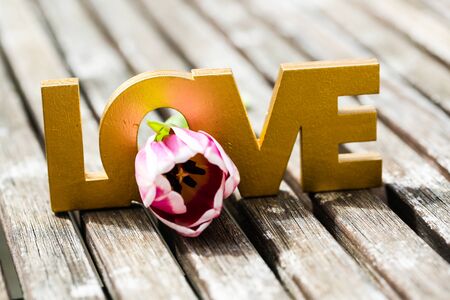 Love, letters, gold colored, wooden backgroundの写真素材