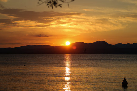 Sunset in Bardolino on Lake Garda with mountains in the backgroundの写真素材