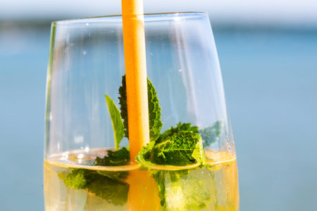 Hugo and Aperol Sprizz together on a wooden table, with the Ammersee in the background