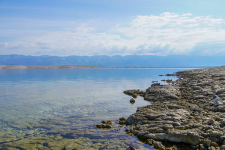A rocky shore near the sea on a sunny day. Summer view. Shore on a daylight. Stones on Shore....