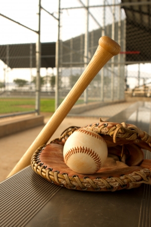 Baseball Bat and Glove on the bench of the dugoutの写真素材
