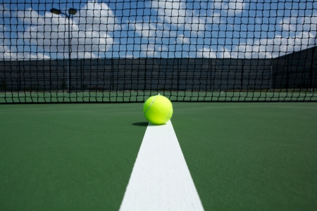 Tennis Ball on the Court Line with the Net in the backgroundの写真素材