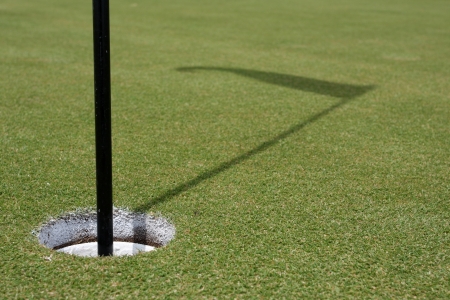 Hole of the green with the flag shadowの写真素材