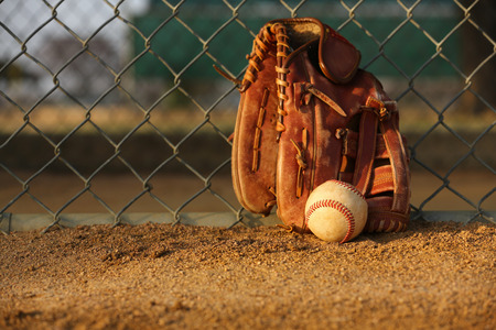 Baseball and Glove against the Field Fenceの写真素材