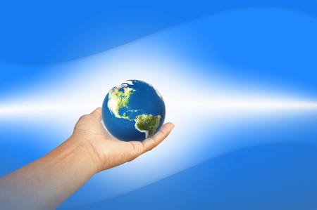 The earth in hand with blue backgroundの写真素材