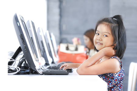 Asian children to using computer in classroomの写真素材