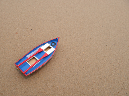 Wooden toy boat on the beach in summer season with bubble sea wave , Top viewの写真素材