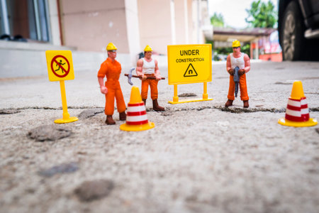 Under construction warning , Maintenance team to repair street cracked , Miniature figure with...