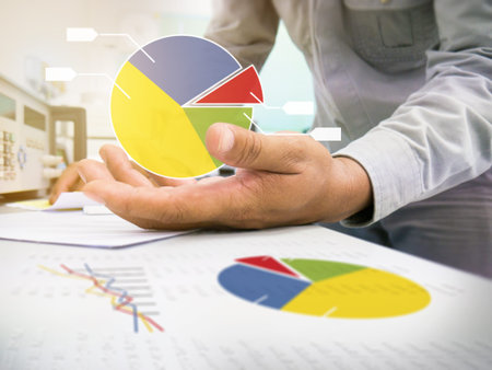 Hand business man check stock chart on working desk with laptop and stock chart graphic on palm ,...