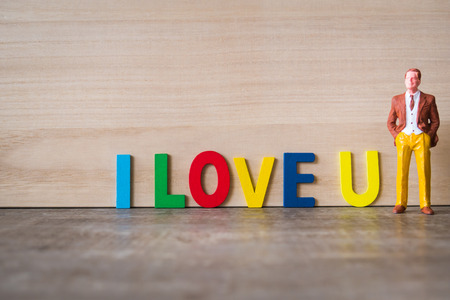 Miniature businessman with love color text on wooden floorの写真素材