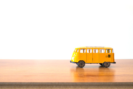 Miniature van toy on the wooden floor and white backgroubdの写真素材