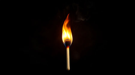 Burning Matchstick with Bright Flame on Dark Backgroundの写真素材