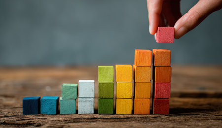 Hand placing colorful wooden blocks in ascending orderの写真素材