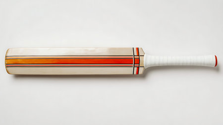 A flat lay, top-down view of a wooden cricket bat positioned horizontally against a white...