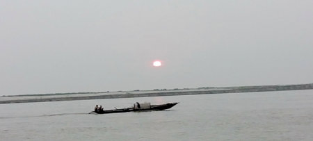 Silhouette of a fishing boat in the middle of the seaの写真素材