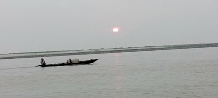 Fisherman on a boat in the river at sunsetの写真素材