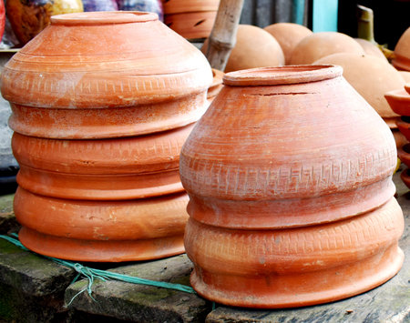 Traditional Handmade clay brown cups, pots and plates in Asian local market,Oriental bazaar. Old...