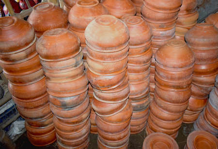 Traditional Handmade clay brown cups, pots and plates in Asian local market,Oriental bazaar. Old pottery. Exhibits ancient times.の写真素材