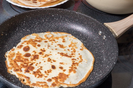 Fried pancake in a pan during frying.
