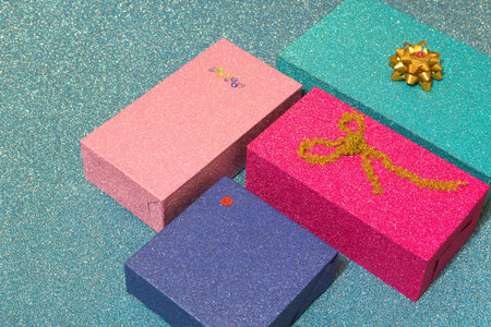 four colorful gift boxes on blue shiny backgroundの写真素材