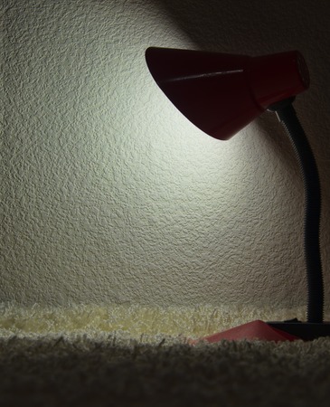 grunge textured picture of a desk lamp shining on a dark wallの写真素材