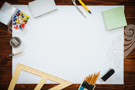 Items for sketching and blank white paper sheet on brown wooden table, top view