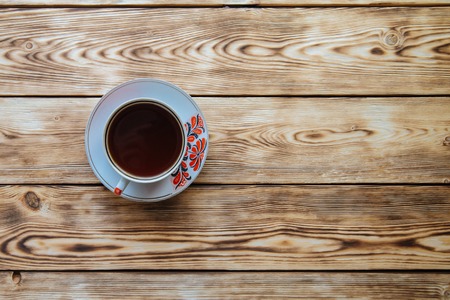 tea mug with red ornaments on old wooden tableの写真素材