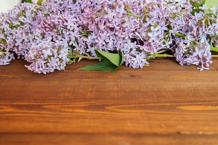 Bunch of lilac flowers on brown wood table with empty space for textの写真素材
