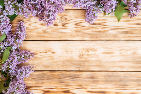 Bunch of lilac flowers on brown wood table with empty space for textの写真素材