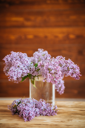 lilac in glass jar on wooden background, selective focusの写真素材