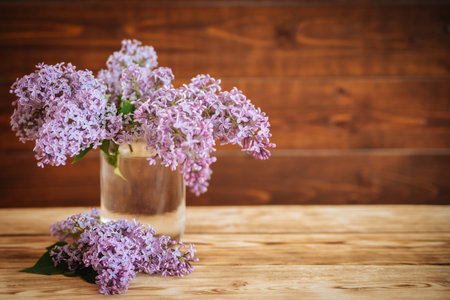 lilac in glass jar on wooden background, selective focusの写真素材