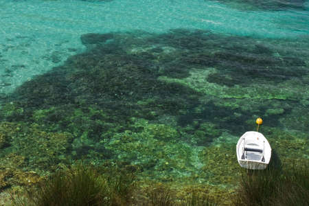 rowing boat moored near the coast in a sea of color smeraldo. Kefalonia, Greeceの写真素材