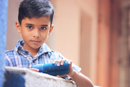 Portrait of Indian little boy holding skipping rope with expression