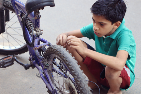 Indian Little Boy repairing cycleの写真素材