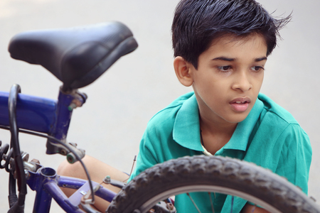 Indian Little Boy repairing cycleの写真素材