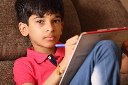Portrait of Indian boy drawing with colorful sketch pen