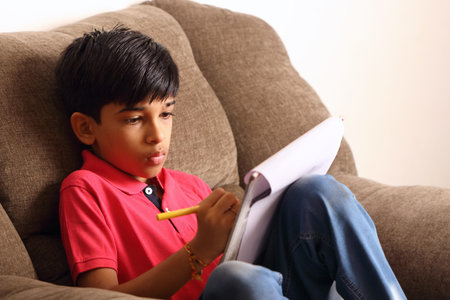 Portrait of Indian boy drawing with colorful sketch pen