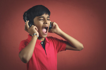 Indian young boy listen music with headphone