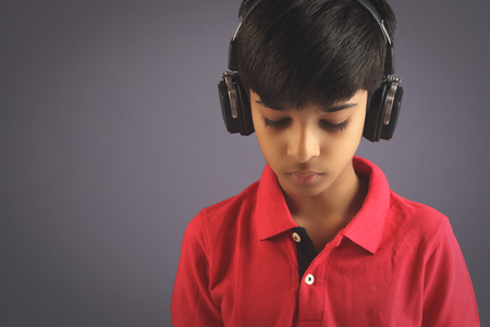Indian young boy listen music with headphoneの写真素材