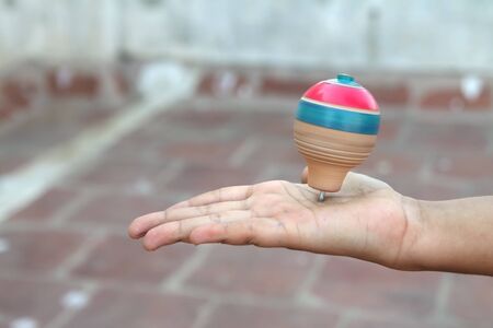 Classic wooden spinning top toy over the palmの写真素材