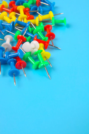 Metal push pins on blue background