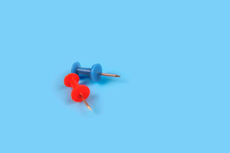 Metal push pins on blue background