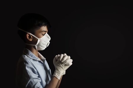 Portrait of Indian boy wearing mask and praying against the Coronavirusの写真素材