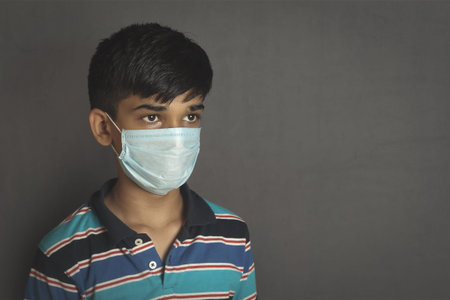 Portrait of young Indian boy wearing protective mask against the coronavirus