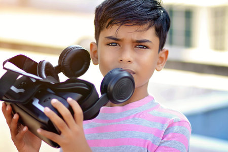 Portrait Indian little boy holding Virtual Reality Glasses