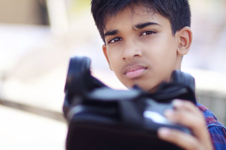 Portrait Indian young boy holding Virtual Reality Glasses