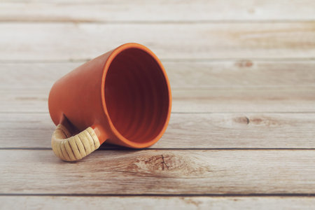 Indian made traditional terracotta coffee cup on wooden table