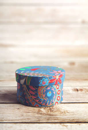 Rounded blue cardboard gift box on wooden tableの写真素材